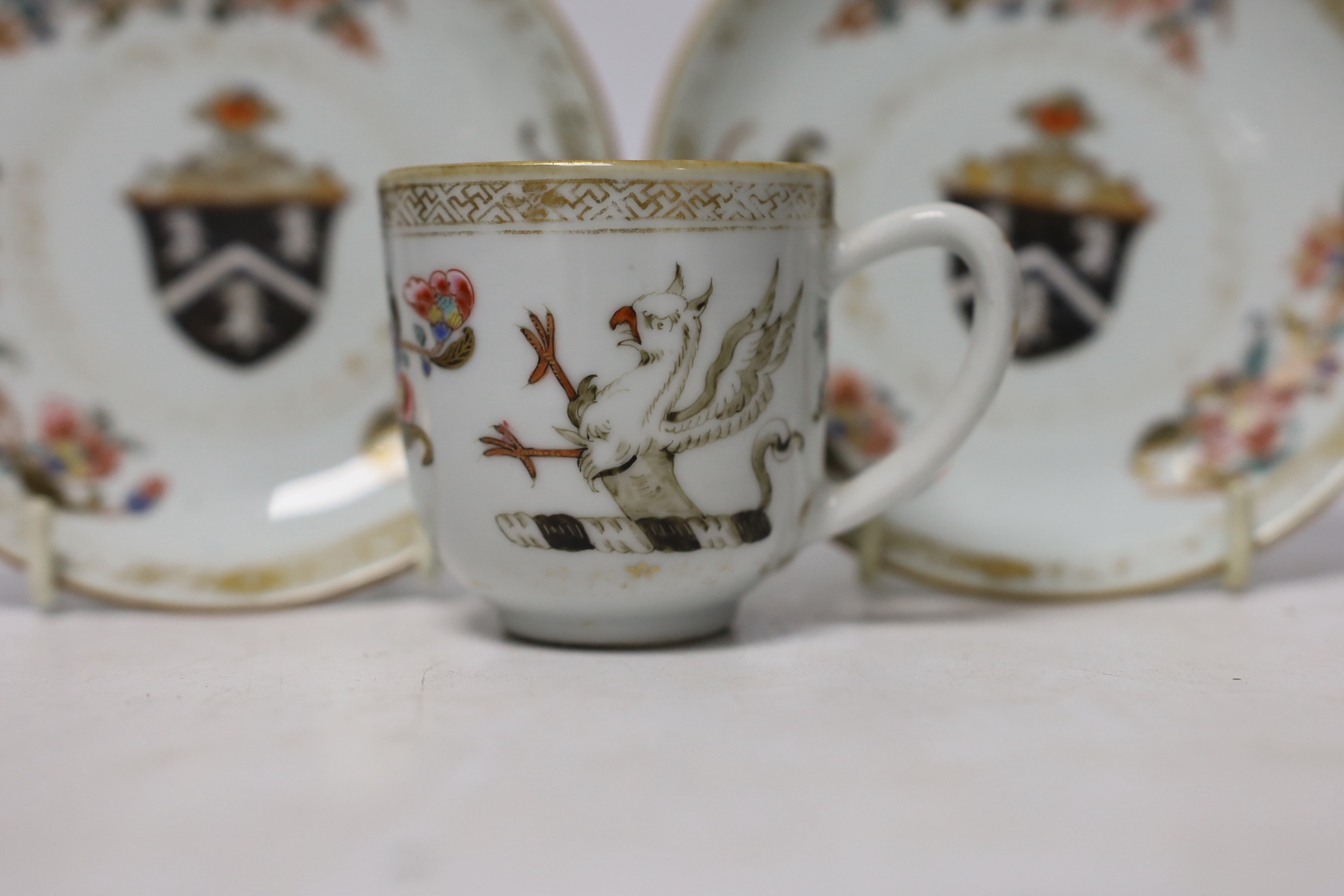 A Chinese armorial coffee cup and two saucers, saucers 12cm in diameter